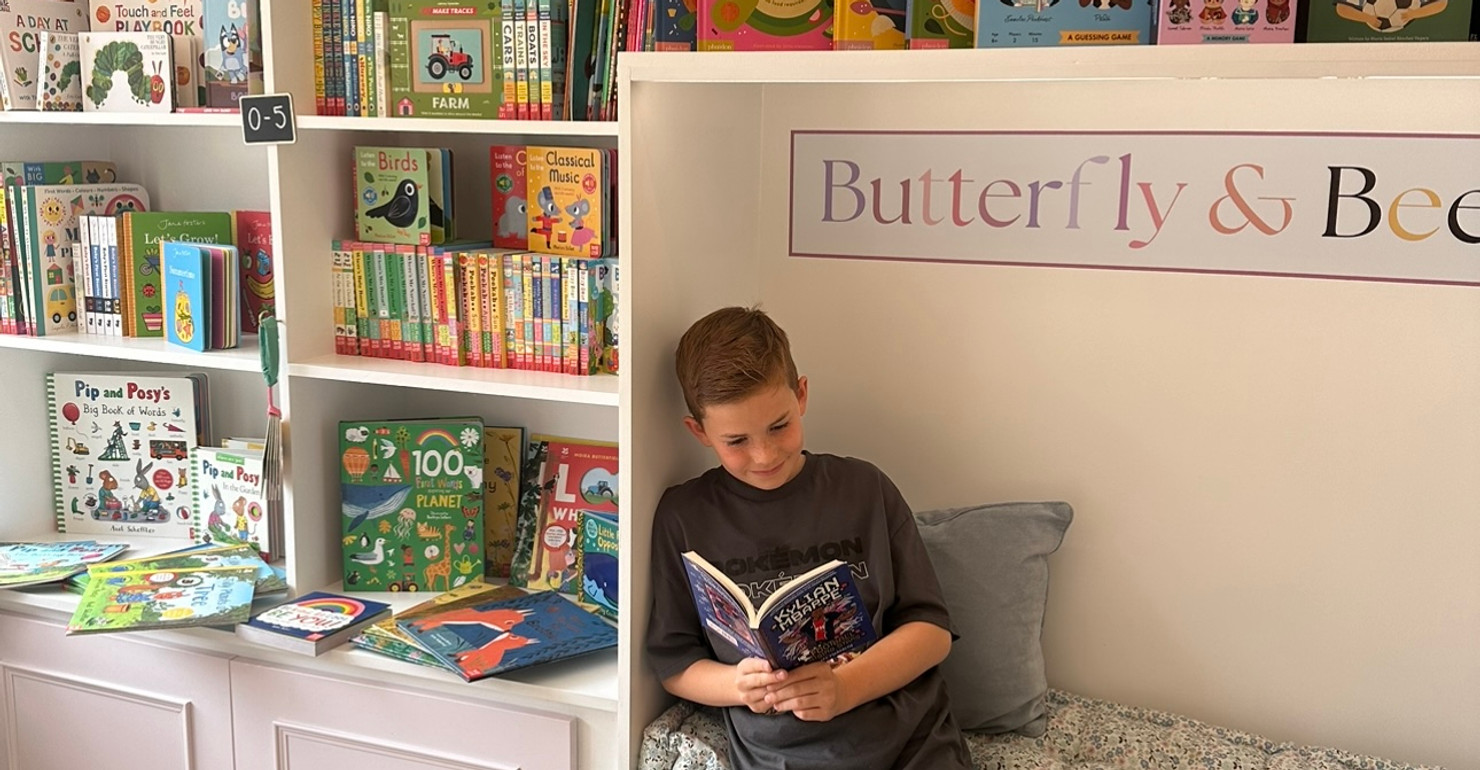Inside the children's bookshop at Tiny Bloom, with picture books displayed face-out on wooden shelves