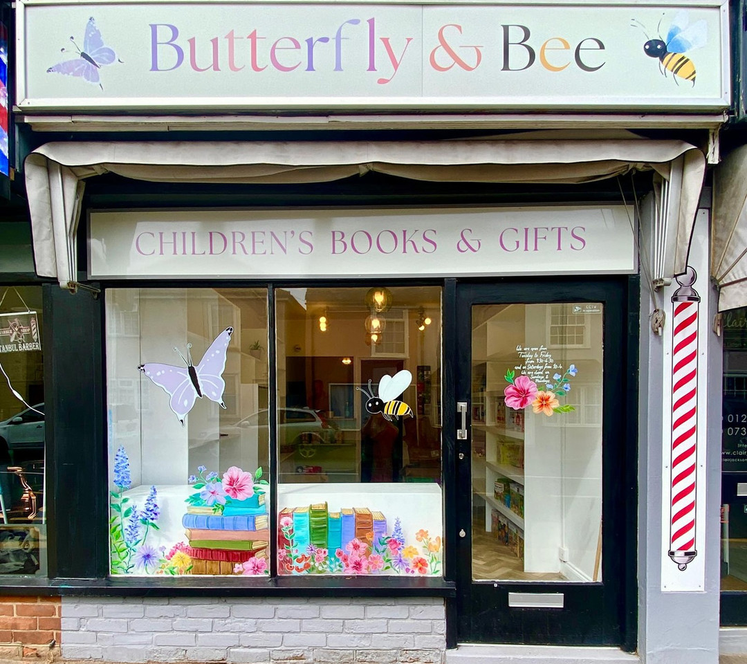 Shelves of children's books and wooden toys inside the Tiny Bloom bookshop