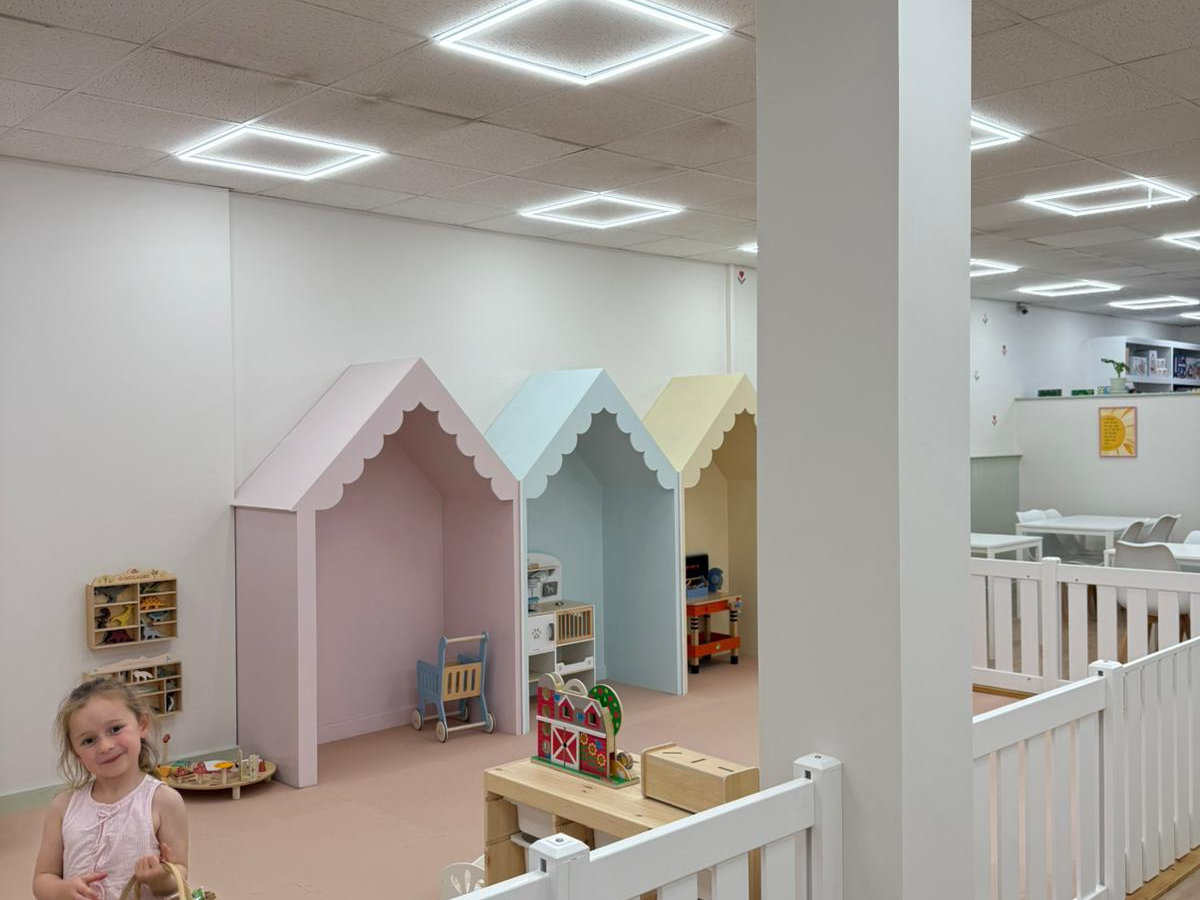 Pastel play houses with scalloped roofs inside Tiny Bloom Play Cafe in Frinton-on-Sea